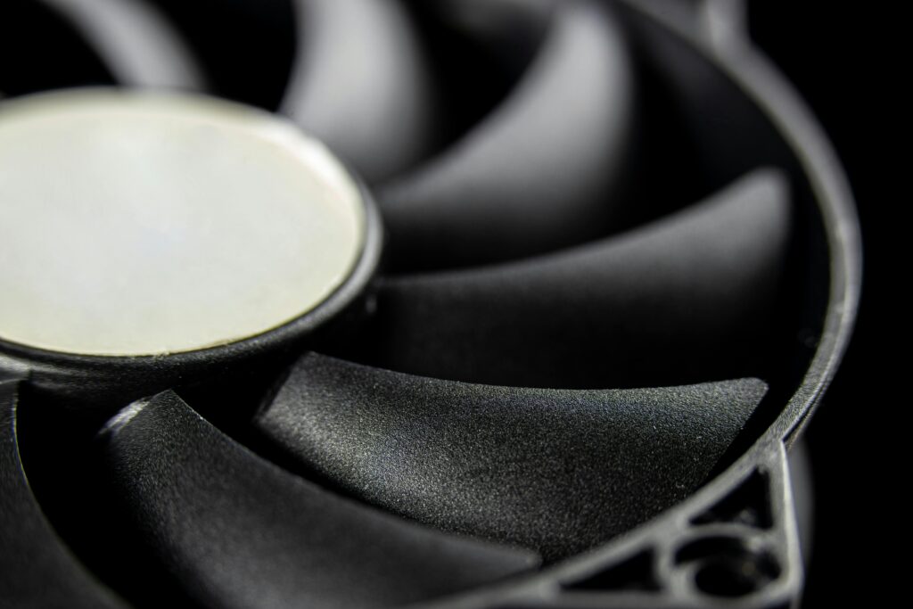 Macro close-up of a modern computer cooling fan blade, showcasing intricate details.